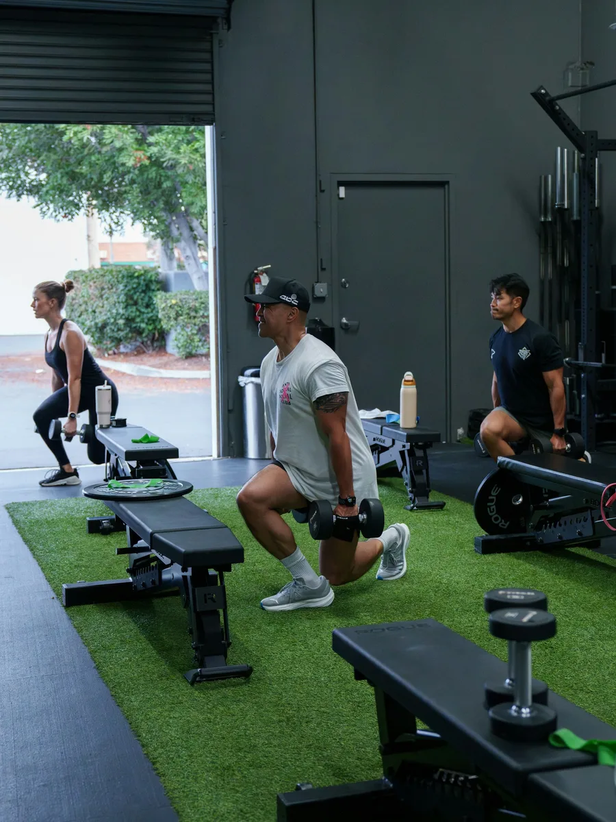 Small group class doing dumbbell lunges