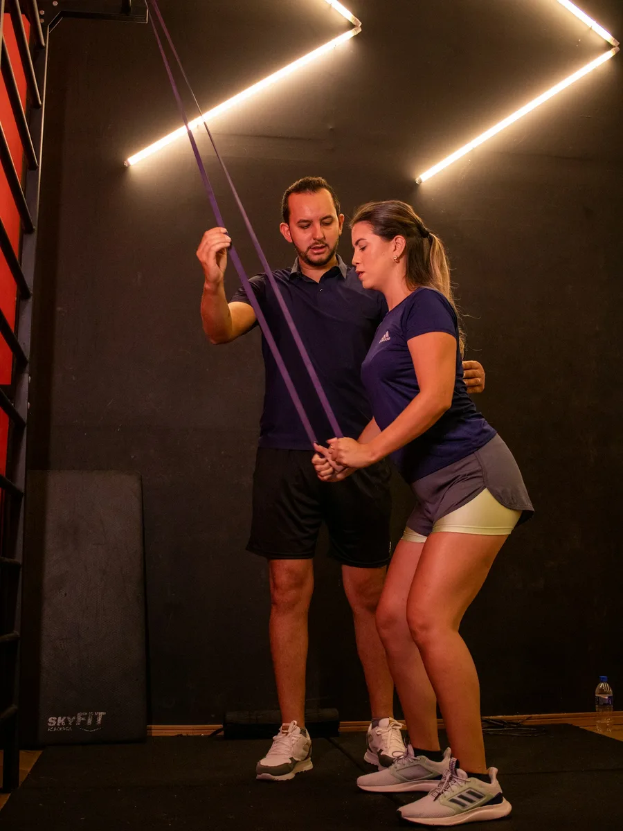 Coach guiding a member through a resistance band exercise